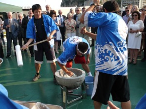 Crew members of the training ship Kojima of Japan Coast Guard demonstrate a traditional method of making rice cakes during the event on board the Kojima
