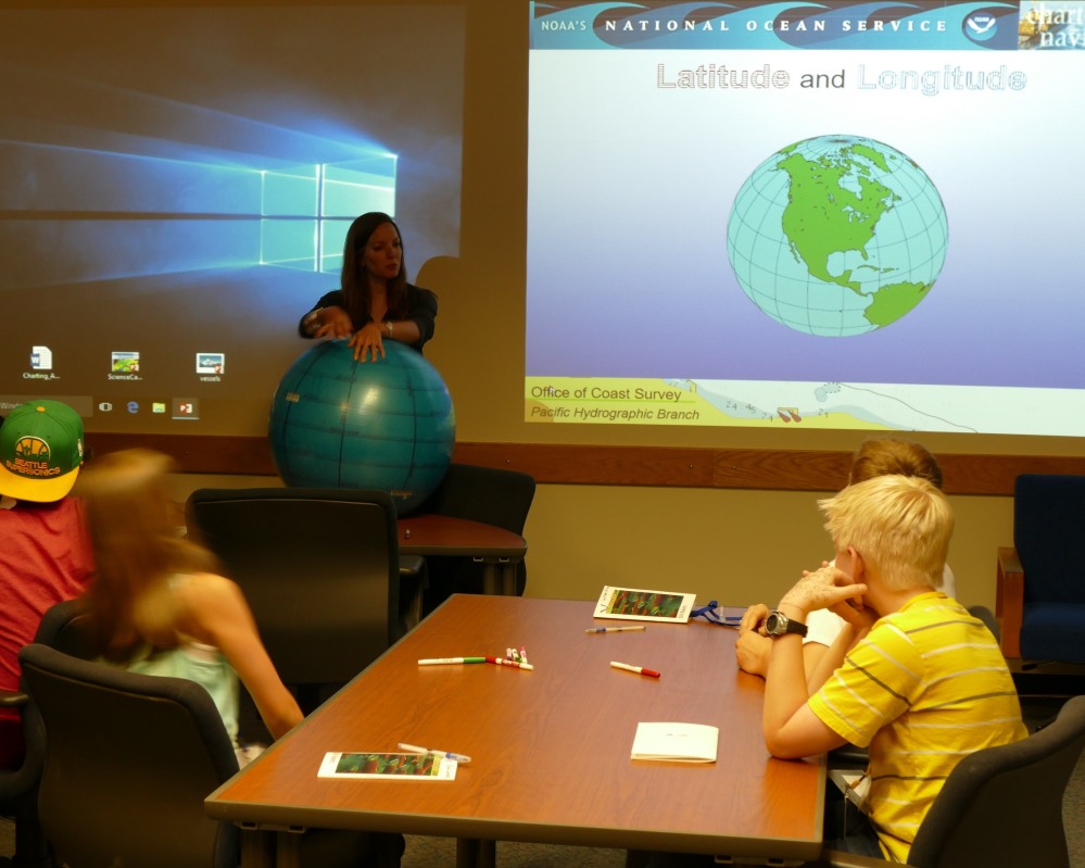 Jessica Ramsay teaches campers about latitude and longitude using a yoga ball globe.